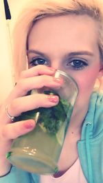 Close-up portrait of a young woman drinking water