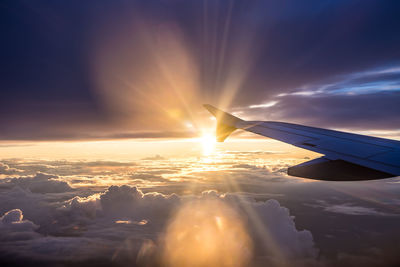 Airplane wing against sky during sunset
