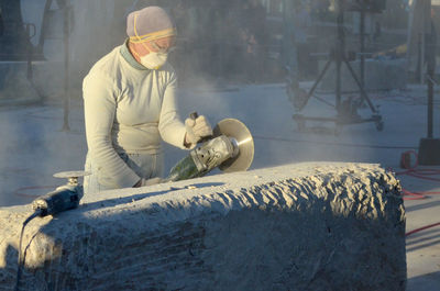 Artist making stone sculpture