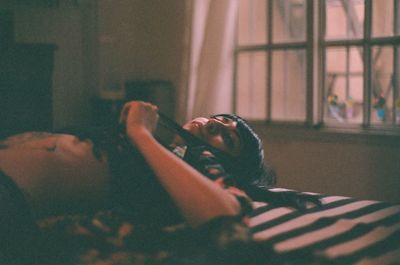 Young woman lying on bed at home