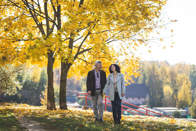 Portrait of a mature couple walking  in an autumn park.