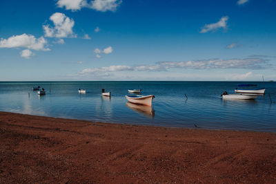 Boats moored on sea against sky