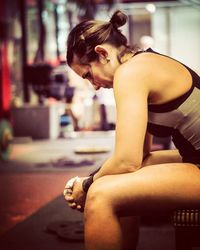 Close-up of young woman sitting in gym