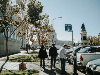 People on street in city against sky