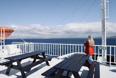 Woman looking at sea against sky