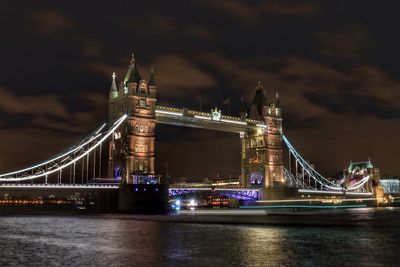 Suspension bridge over river at night