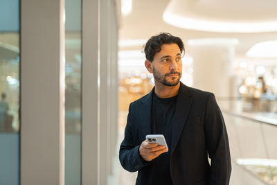 Portrait of young man standing in office