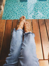 Low section of woman sitting at poolside