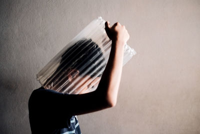 Low section of woman standing against wall