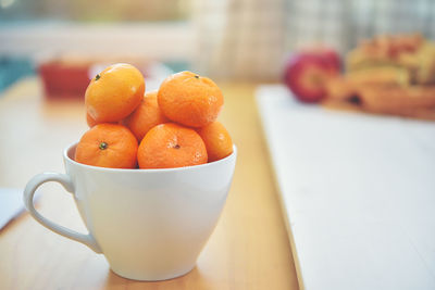 Close-up of orange fruits in bowl on table