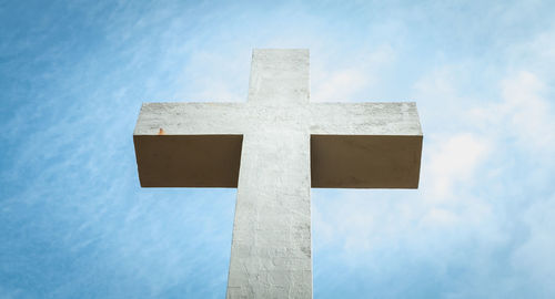 Low angle view of cross against sky