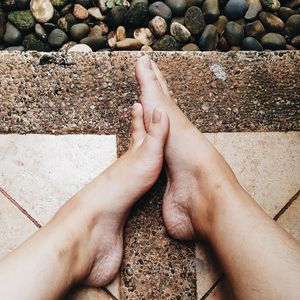 Low section of person legs on pebbles at beach