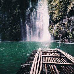 Wooden raft in river against tinago falls