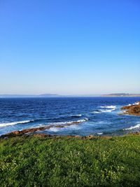 Scenic view of sea against clear blue sky