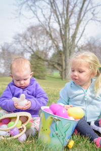 Siblings playing with toys on field