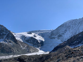 Scenic view of snowcapped mountains against clear blue sky