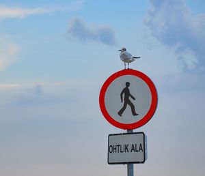 Low angle view of signboard against sky