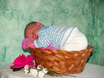 Close-up of baby boy sleeping in basket