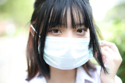 Portrait of young woman wearing mask standing outdoors