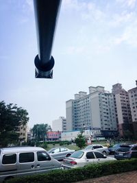 Cars on road in city against sky