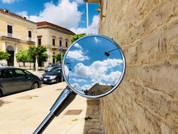 Reflection of buildings on street against sky