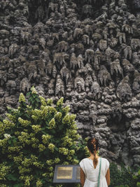 Rear view of woman standing against wall