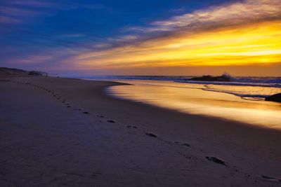 Scenic view of beach against sky during sunset