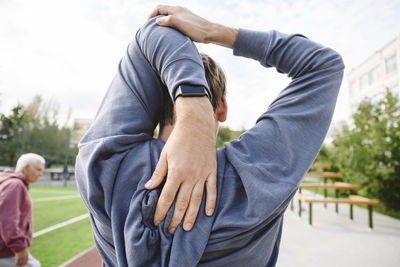 Man stretching in sports field