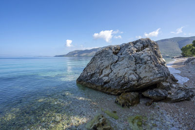 Rock formation in sea against sky