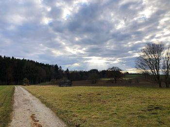 Road amidst field against sky