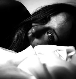 Close-up portrait of woman lying on bed