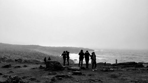 People at beach against sky