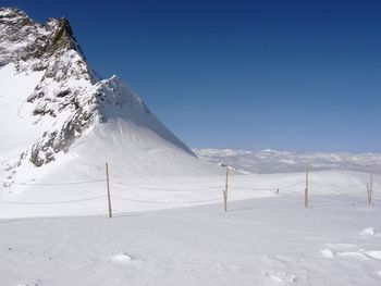 Scenic view of snowcapped mountains against clear blue sky