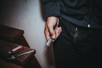 Midsection of man smoking cigarette