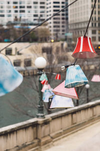 Lamps hanging on street against buildings in city