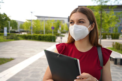 Portrait of young woman looking away wearing protective face mask