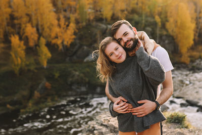 Happy people in love are travel hike in nature in the autumn forest. romantic trip to countryside