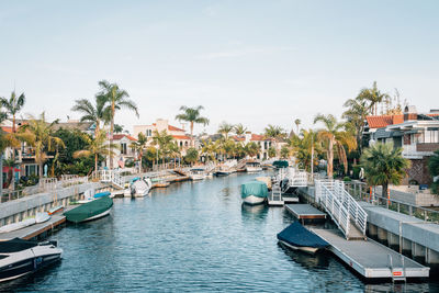 Boats moored at harbor against sky