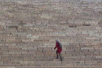 Full length of man walking against brick wall