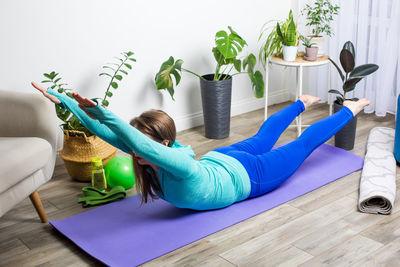 Woman lying on potted plant at home