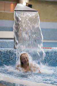 Cheerful woman enjoying in swimming pool