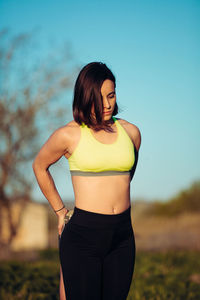 Beautiful woman standing on field against sky