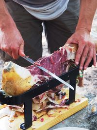 Midsection of man preparing jamón