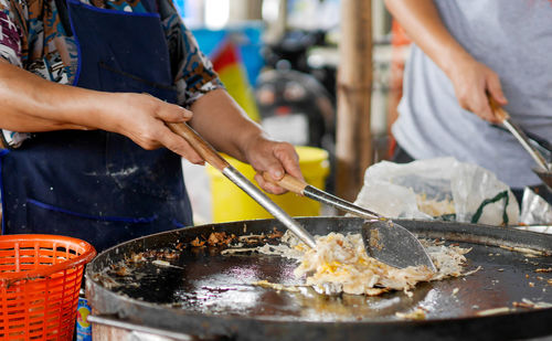 Midsection of man preparing food at market stall