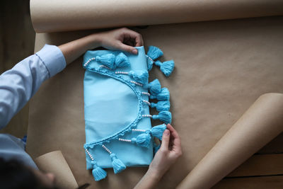 Woman packs a handicraft thing into craft paper, a small business and customer care.