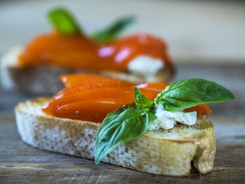 Close-up of bruschettas with feta cheese and marinated bell pepper served on table