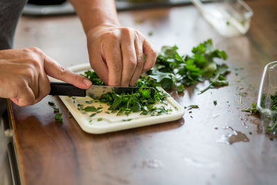 Close-up of person chopping herbs