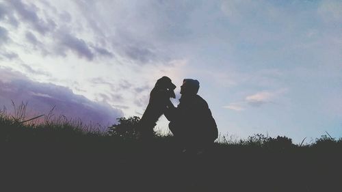 Silhouette of people against cloudy sky