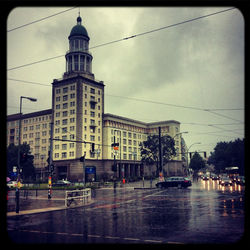 Buildings in city against cloudy sky