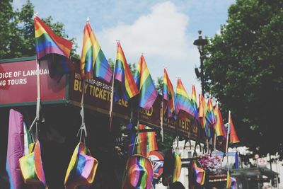 Multi colored flags in city against sky